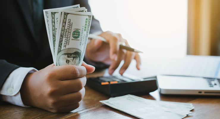 Businessman using calculator and holding money calculate Commerc